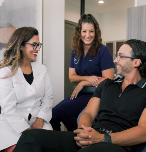 staff holding dental equipment and smiling in Oklahoma City